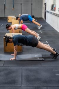 Person macht Plank-Übung in einem Fitnessstudio, um Bauchfett zu reduzieren und die Bauchmuskeln zu stärken.